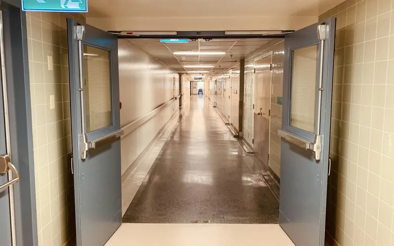 Pasillo de un hospital visto desde unas puertas abiertas